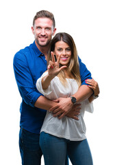 Young couple in love over isolated background showing and pointing up with fingers number three while smiling confident and happy.