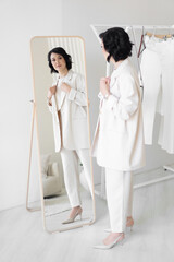 Woman is going to work. He picks up a business look for the day in front of the mirror in his dressing room. Business fashion.