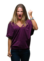 Young beautiful blonde elegant woman over isolated background angry and mad raising fist frustrated and furious while shouting with anger. Rage and aggressive concept.