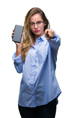 Young beautiful blonde business woman showing screen of smartphone over isolated background pointing with finger to the camera and to you, hand sign, positive and confident gesture from the front