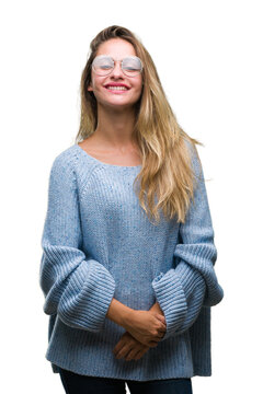 Young beautiful blonde woman wearing sweater and glasses over isolated background with a happy and cool smile on face. Lucky person.