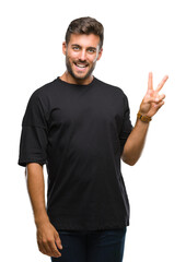 Young handsome man over isolated background smiling with happy face winking at the camera doing victory sign. Number two.