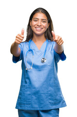 Young arab doctor surgeon woman over isolated background approving doing positive gesture with...