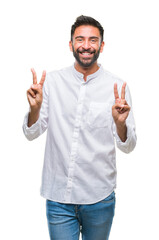 Adult hispanic man over isolated background smiling looking to the camera showing fingers doing victory sign. Number two.