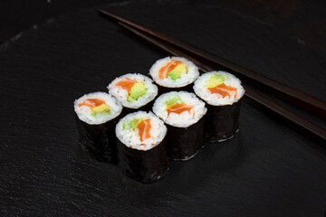 Set of tuna sushi rolls on black desk background