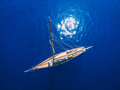 Top view of sailing yacht in the sea while the sun is shining.