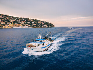 Fishing trawler coming back from the job next to the island in Italy - obrazy, fototapety, plakaty