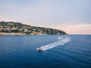 Obraz premium Three speedboats going next to the island in the evening