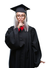 Young blonde woman wearing graduate uniform over isolated background asking to be quiet with finger...