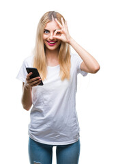 Naklejka premium Young beautiful blonde woman using smartphone over isolated background with happy face smiling doing ok sign with hand on eye looking through fingers