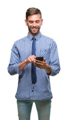 Young hadsome man texting sending message using smartphone over isolated background with a happy...