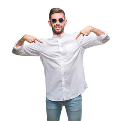 Young handsome man wearing glasses over isolated background looking confident with smile on face, pointing oneself with fingers proud and happy.