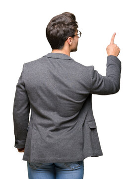 Young Business Man Wearing Glasses Over Isolated Background Posing Backwards Pointing Behind With Finger Hand