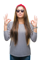 Obraz na płótnie Canvas Young beautiful caucasian woman wearing sunglasses over isolated background relax and smiling with eyes closed doing meditation gesture with fingers. Yoga concept.
