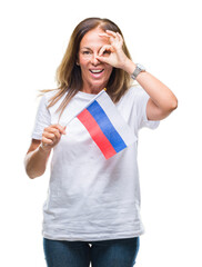 Fototapeta premium Middle age hispanic woman holding flag of Russia over isolated background with happy face smiling doing ok sign with hand on eye looking through fingers