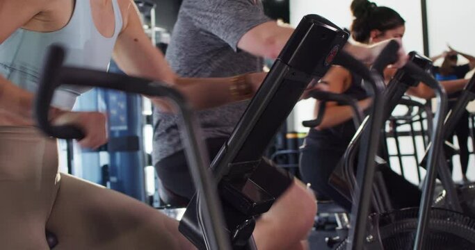 Group of athletes exercise on spin bikes during a cross training class