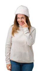 Beautiful middle age woman wearing winter sweater and hat over isolated background Pointing to the eye watching you gesture, suspicious expression