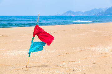 Position Mark Flag at Landscape / Red and blue signal flags pinned on beach sand at sunny coast (copy space)