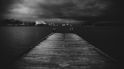 Black and white image of a pier and the ocean