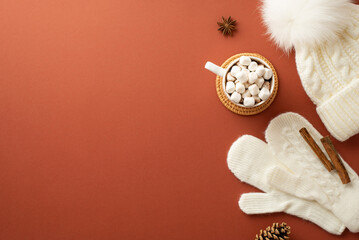 Winter concept. Top view photo of knitted bobble hat mittens cup of cocoa with marshmallow on...