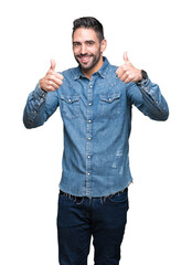 Young handsome man over isolated background success sign doing positive gesture with hand, thumbs up smiling and happy. Looking at the camera with cheerful expression, winner gesture.