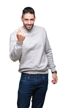 Young handsome man wearing sweatshirt over isolated background Beckoning come here gesture with hand inviting happy and smiling