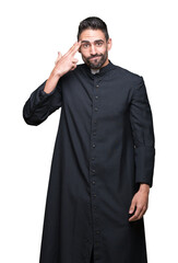 Fototapeta premium Young Christian priest over isolated background Shooting and killing oneself pointing hand and fingers to head, suicide gesture.