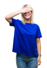 Young beautiful blonde woman wearing glasses over isolated background smiling and laughing with hand on face covering eyes for surprise. Blind concept.