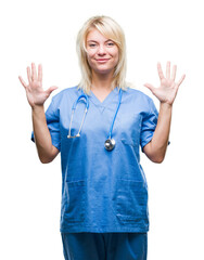 Young beautiful blonde doctor woman wearing medical uniform over isolated background showing and pointing up with fingers number ten while smiling confident and happy.