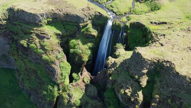 Drone Over Green Landscape Surrounding Gljufrabui Waterfall