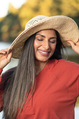 Beautiful Asian Indian woman wearing a hat by the lake.