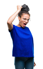 Young braided hair african american girl wearing glasses over isolated background angry and mad raising fist frustrated and furious while shouting with anger. Rage and aggressive concept.