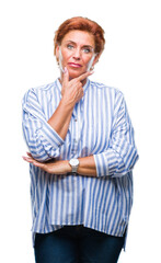 Atrractive senior caucasian redhead woman over isolated background looking confident at the camera with smile with crossed arms and hand raised on chin. Thinking positive.