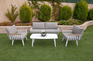 3 white sofa and table made of metal in the yard and garden on the lawn
