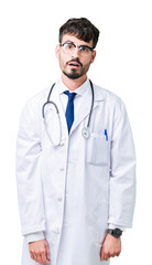 Fototapeta premium Young doctor man wearing hospital coat over isolated background afraid and shocked with surprise expression, fear and excited face.