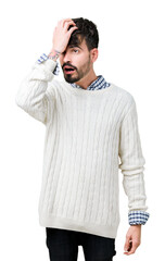 Young handsome man wearing winter sweater over isolated background surprised with hand on head for...