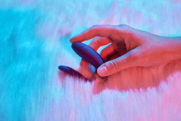 desire concept : Woman lying in bed holding a dildo vibrator in her hand to help herself.