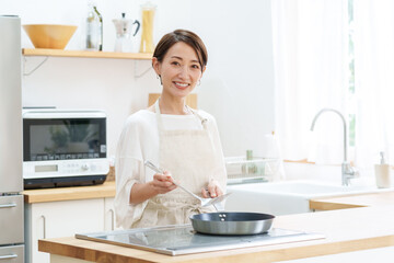 Obraz na płótnie Canvas キッチンで料理をする女性のポートレート