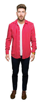 Young handsome man wearing red shirt afraid and shocked with surprise expression, fear and excited face.