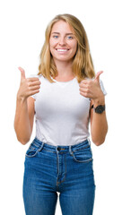 Beautiful young woman wearing casual white t-shirt over isolated background success sign doing...