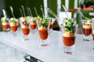 Cocktail party with variety of desserts and food decorated in small shot glasses