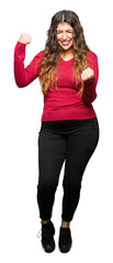 Young beautiful woman wearing red sweater very happy and excited doing winner gesture with arms...