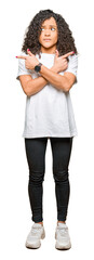 Fototapeta premium Young beautiful woman with curly hair wearing white t-shirt Pointing to both sides with fingers, different direction disagree