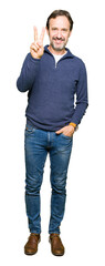 Fototapeta premium Middle age handsome man wearing a sweater showing and pointing up with fingers number two while smiling confident and happy.