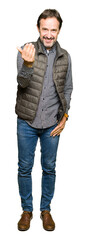 Fototapeta premium Middle age handsome man wearing winter vest Beckoning come here gesture with hand inviting happy and smiling