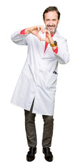 Fototapeta premium Middle age therapist wearing white coat smiling in love showing heart symbol and shape with hands. Romantic concept.