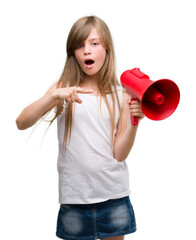 Young blonde toddler holding megaphone very happy pointing with hand and finger
