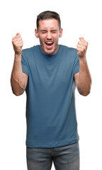 Fototapeta premium Handsome young casual man excited for success with arms raised celebrating victory smiling. Winner concept.