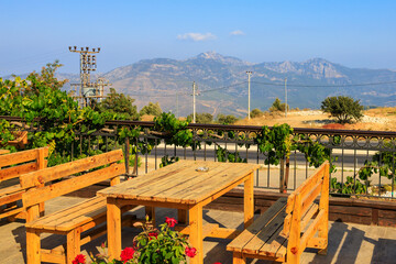 Wooden tables on the terrace of a restaurant in the mountains with a beautiful view. Southern coastal Taurus, Turkey