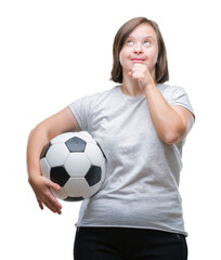 Young adult woman with down syndrome holding soccer football ball over isolated background serious...